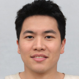 Joyful asian young-adult male with short  brown hair and brown eyes