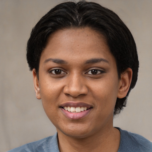 Joyful black young-adult female with short  black hair and brown eyes