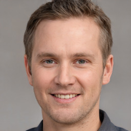 Joyful white young-adult male with short  brown hair and grey eyes