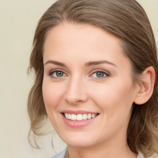 Joyful white young-adult female with medium  brown hair and blue eyes