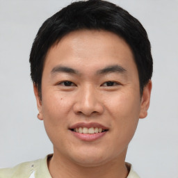 Joyful asian young-adult male with short  black hair and brown eyes