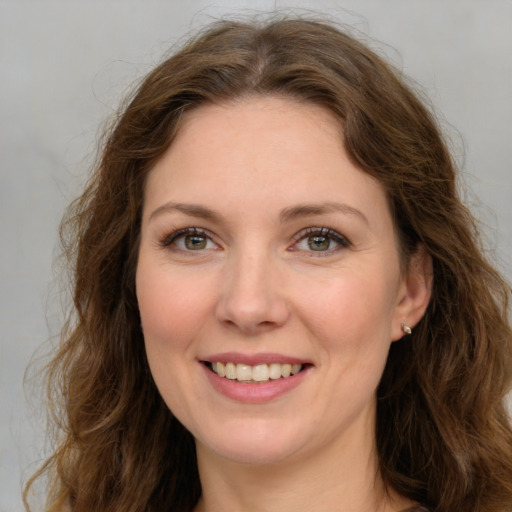 Joyful white adult female with long  brown hair and green eyes