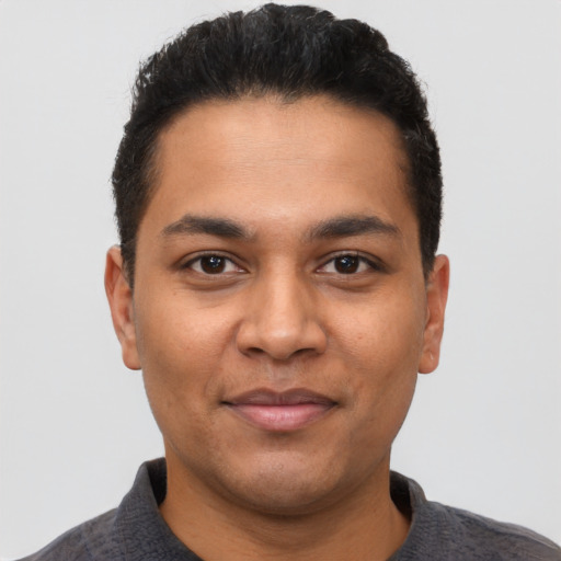 Joyful latino young-adult male with short  black hair and brown eyes