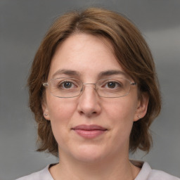 Joyful white adult female with medium  brown hair and grey eyes