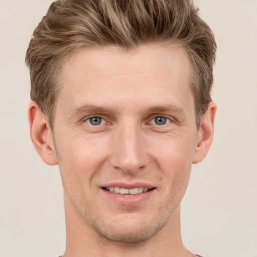 Joyful white young-adult male with short  brown hair and grey eyes