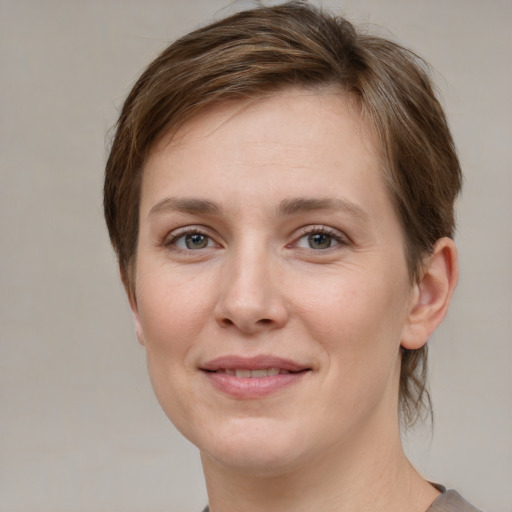 Joyful white young-adult female with short  brown hair and grey eyes