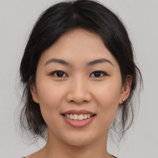 Joyful asian young-adult female with medium  brown hair and brown eyes