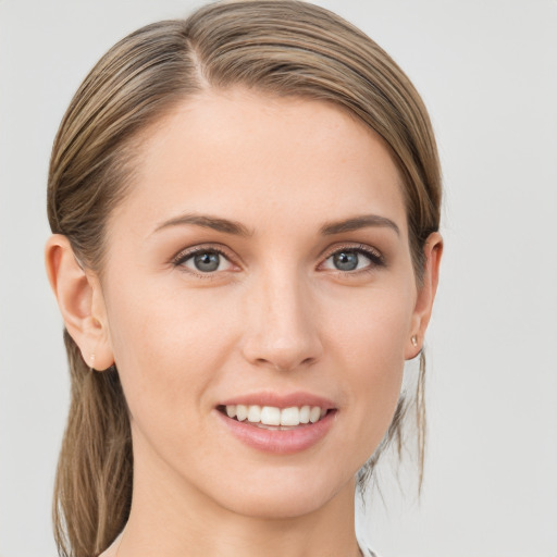 Joyful white young-adult female with medium  brown hair and grey eyes