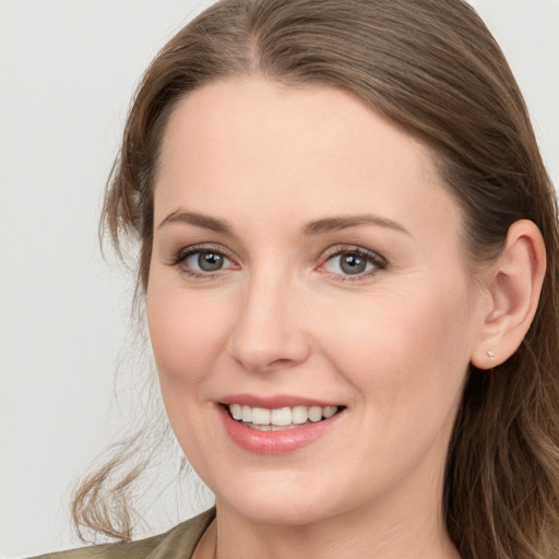 Joyful white young-adult female with long  brown hair and blue eyes