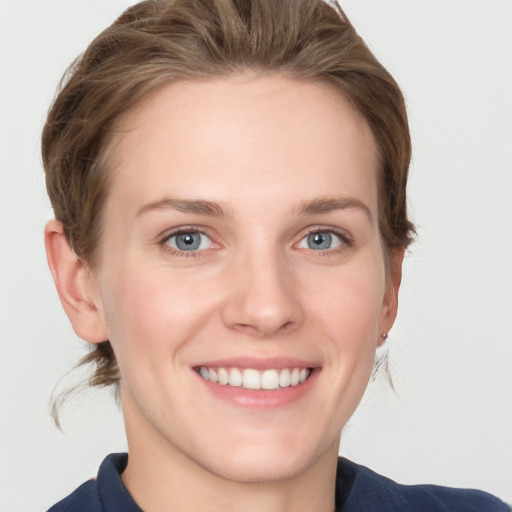 Joyful white young-adult female with medium  brown hair and grey eyes