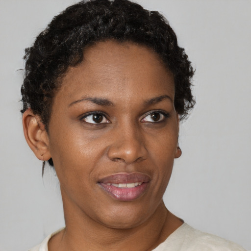 Joyful black adult female with short  brown hair and brown eyes