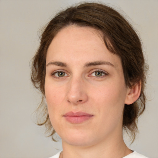 Joyful white young-adult female with medium  brown hair and green eyes