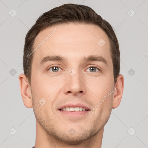 Joyful white young-adult male with short  brown hair and grey eyes