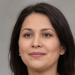 Joyful white adult female with long  brown hair and brown eyes