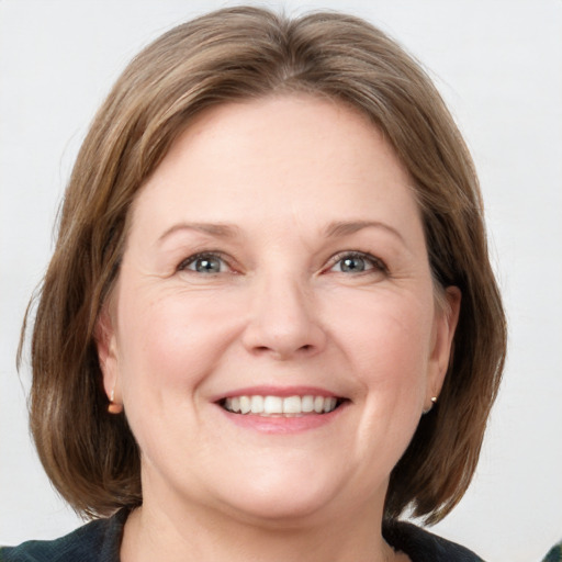 Joyful white adult female with medium  brown hair and blue eyes