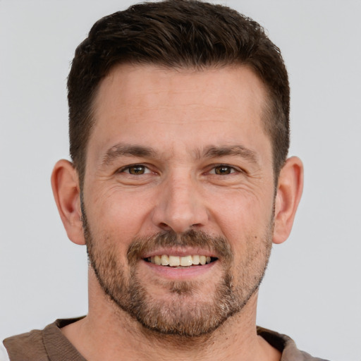 Joyful white adult male with short  brown hair and brown eyes