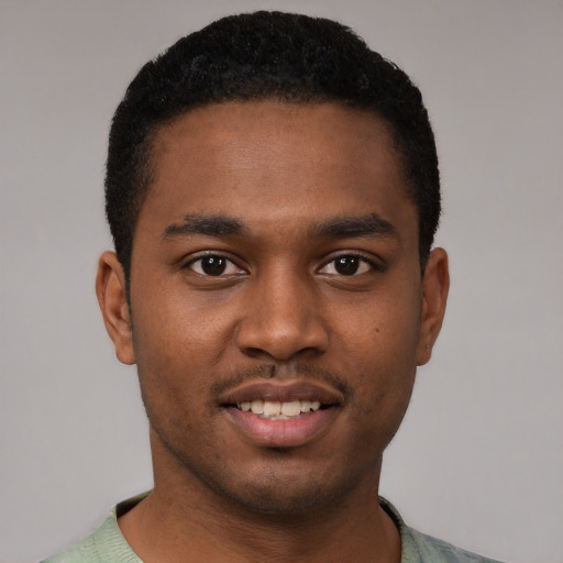 Joyful black young-adult male with short  black hair and brown eyes