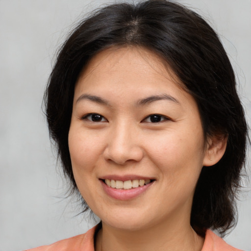 Joyful asian young-adult female with medium  brown hair and brown eyes