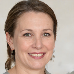 Joyful white adult female with medium  brown hair and green eyes