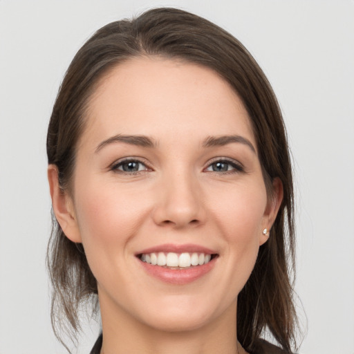 Joyful white young-adult female with medium  brown hair and grey eyes