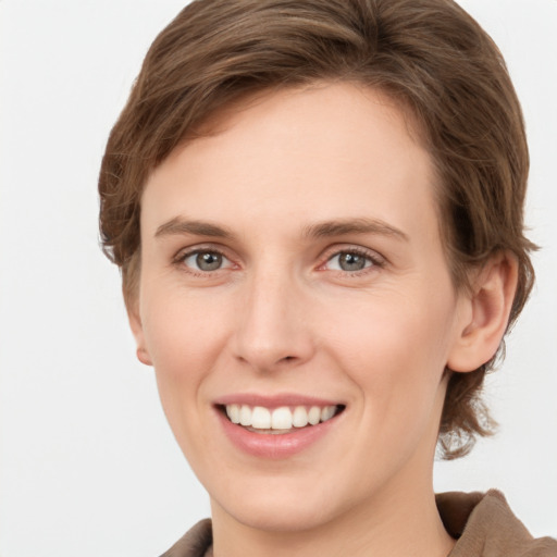 Joyful white young-adult female with short  brown hair and grey eyes