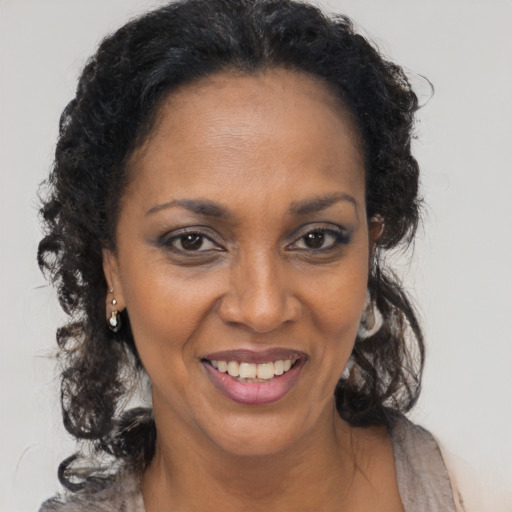 Joyful black adult female with long  brown hair and brown eyes