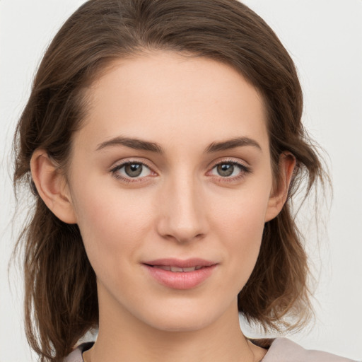 Joyful white young-adult female with medium  brown hair and grey eyes