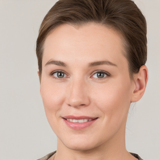 Joyful white young-adult female with short  brown hair and grey eyes