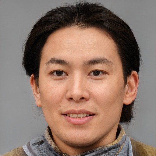 Joyful asian adult male with medium  brown hair and brown eyes