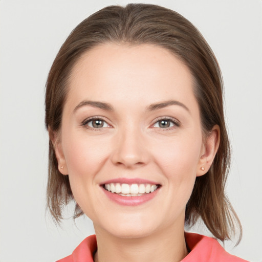 Joyful white young-adult female with medium  brown hair and grey eyes