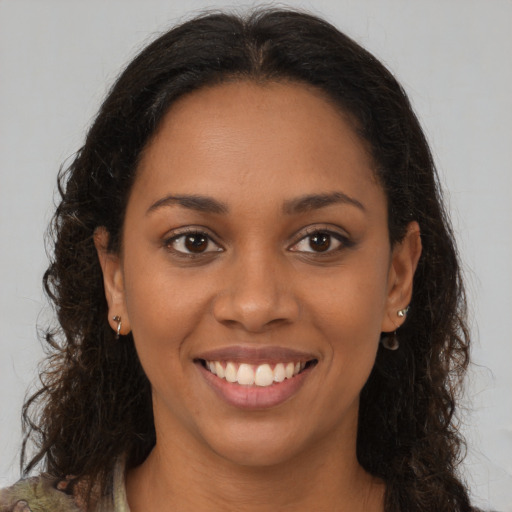 Joyful latino young-adult female with long  brown hair and brown eyes