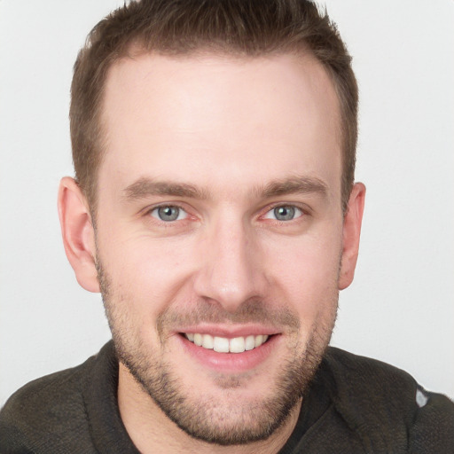 Joyful white young-adult male with short  brown hair and grey eyes