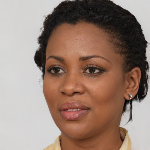 Joyful black young-adult female with short  brown hair and brown eyes