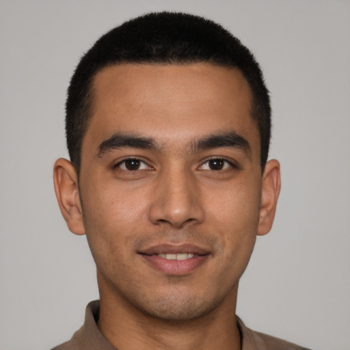 Joyful latino young-adult male with short  brown hair and brown eyes