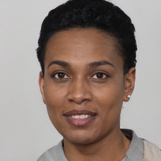 Joyful black young-adult female with short  black hair and brown eyes