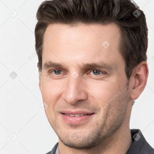 Joyful white adult male with short  brown hair and grey eyes