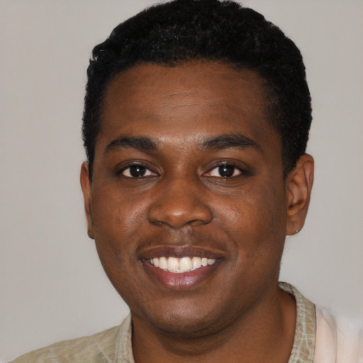 Joyful black young-adult male with short  black hair and brown eyes