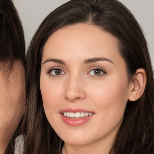 Joyful white young-adult female with long  brown hair and brown eyes