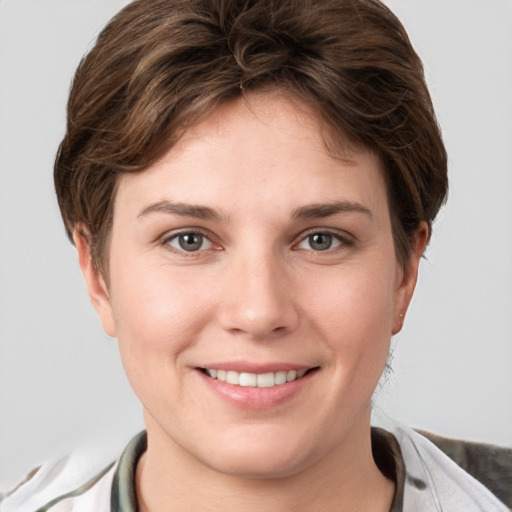 Joyful white young-adult female with short  brown hair and grey eyes