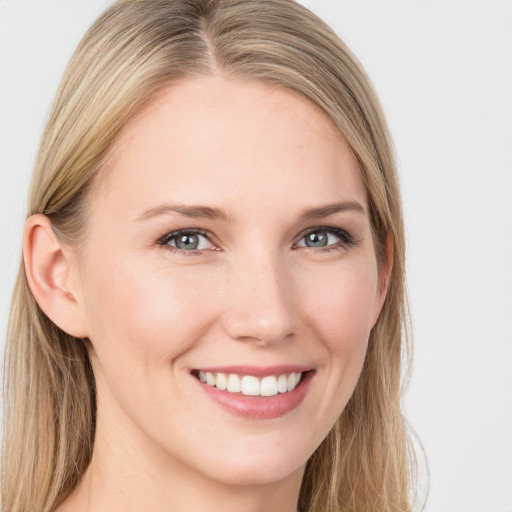 Joyful white young-adult female with long  brown hair and blue eyes