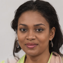 Joyful black young-adult female with long  brown hair and brown eyes