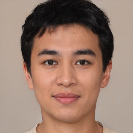 Joyful asian young-adult male with short  black hair and brown eyes
