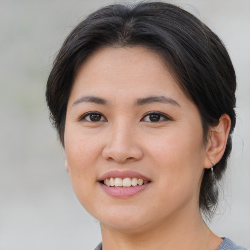 Joyful asian young-adult female with medium  brown hair and brown eyes