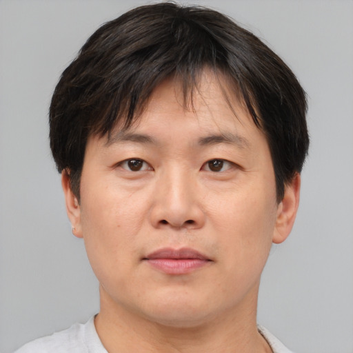 Joyful asian adult male with short  brown hair and brown eyes