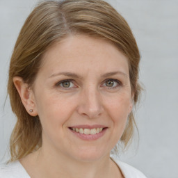 Joyful white adult female with medium  brown hair and grey eyes