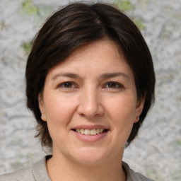 Joyful white adult female with medium  brown hair and grey eyes