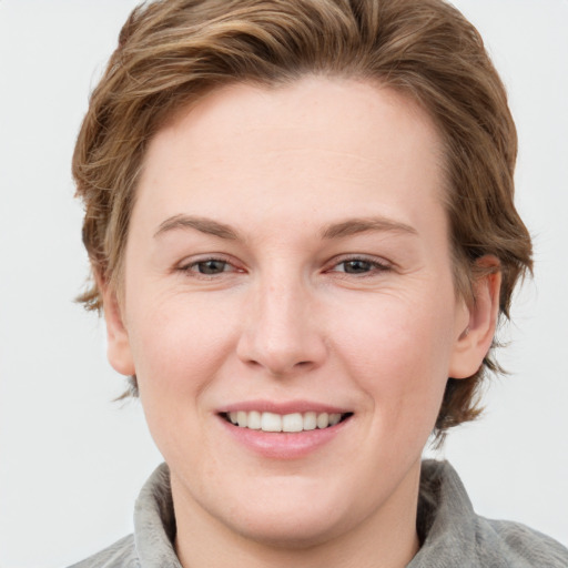 Joyful white young-adult female with medium  brown hair and grey eyes