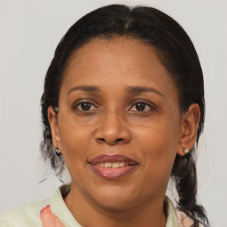 Joyful black adult female with medium  brown hair and brown eyes