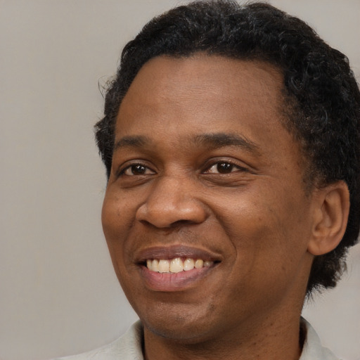 Joyful black adult male with short  brown hair and brown eyes