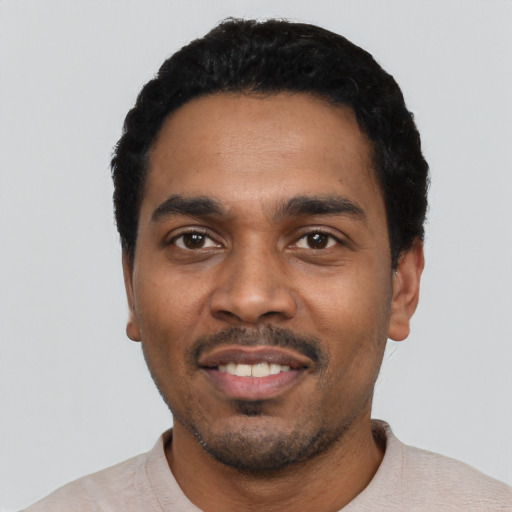 Joyful black young-adult male with short  black hair and brown eyes